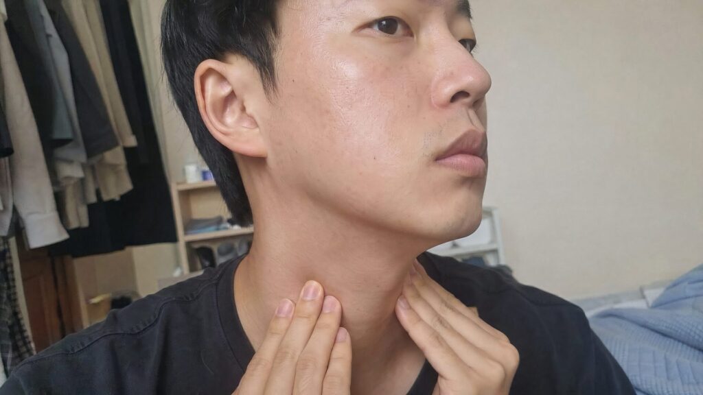 목에 만져지는 멍울을 확인하는 모습
